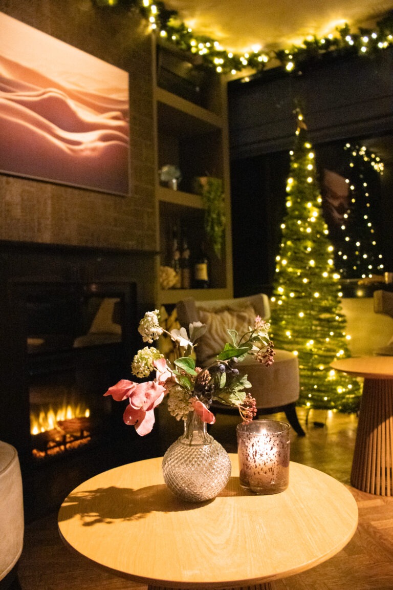 Tafeltje bij de open haard met bloemen en een kaarsje