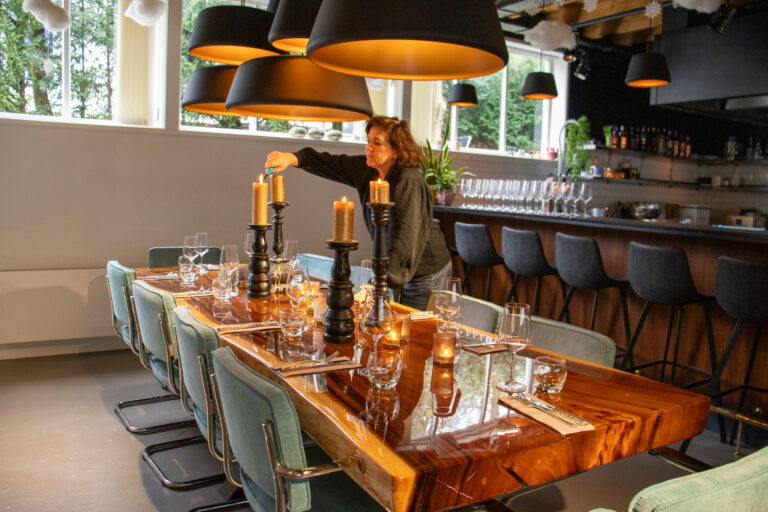Femke steekt een kaars aan bij Wildschut op een gedekte tafel