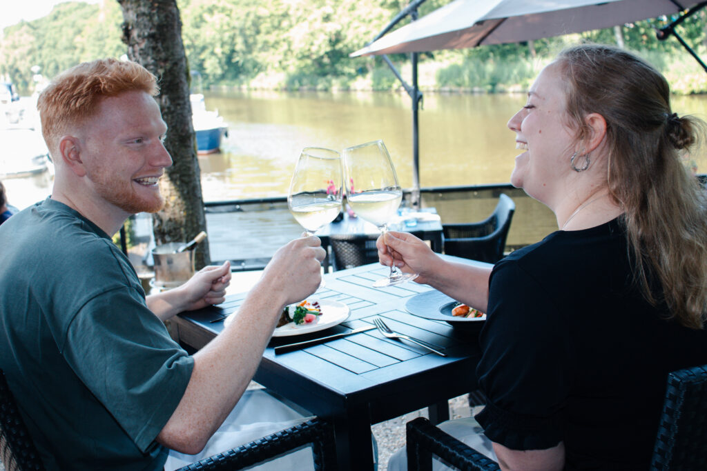 twee mensen proosten aan het water