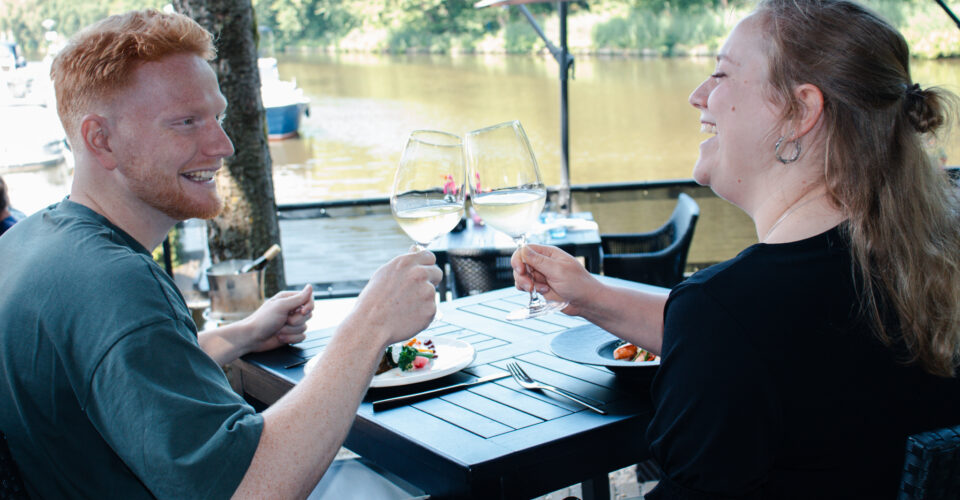 twee mensen proosten aan het water