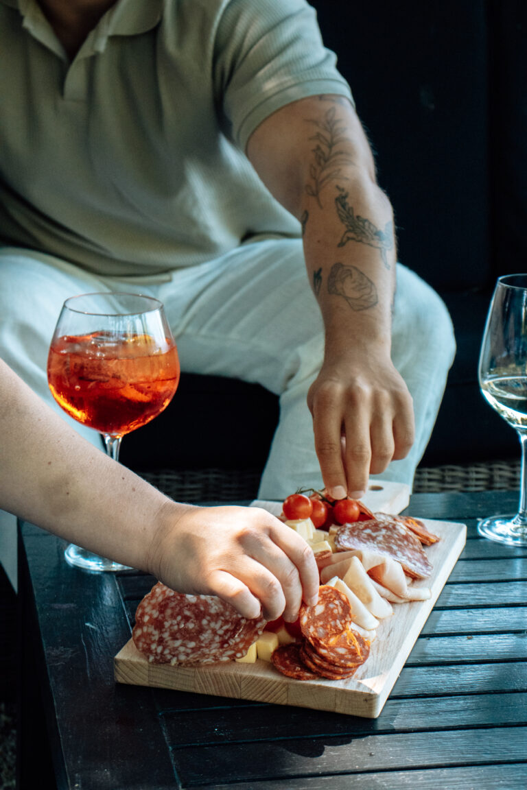 Daam pakt vlees van een charcuterie bord